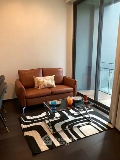 Modern living room with stylish sofa and glass coffee table, featuring a chic balcony view.