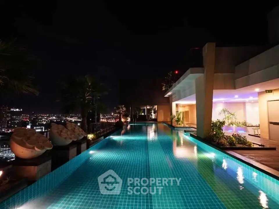 Luxurious rooftop pool with stunning city night view, perfect for relaxation and entertainment.