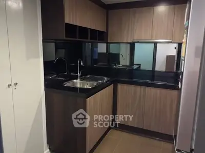 Modern kitchen with sleek black countertops and wooden cabinets