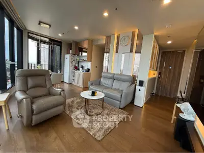 Spacious modern living room with leather sofas and city view, perfect for relaxation and entertainment.
