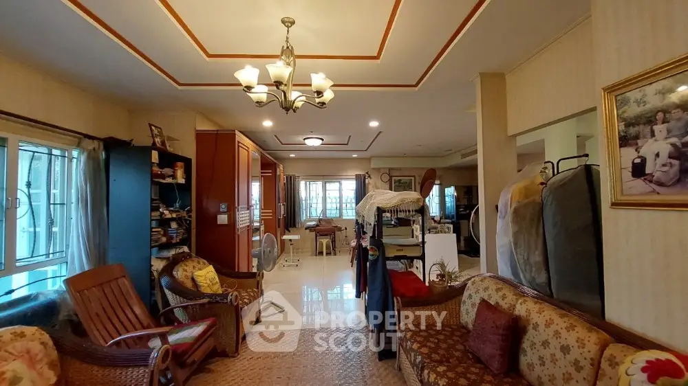 Spacious living room with elegant lighting, comfortable seating, and a warm ambiance, leading to a cozy dining area.