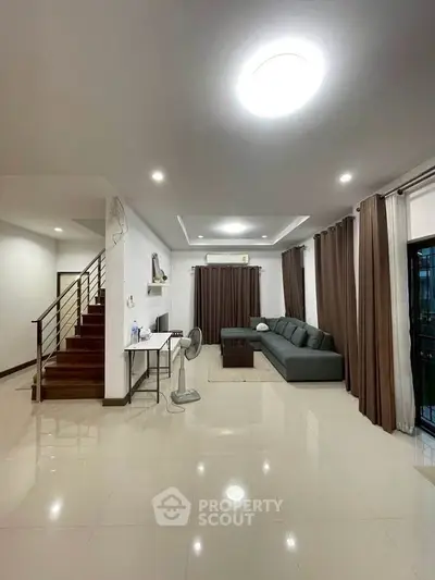 Spacious modern living room with sleek design and elegant staircase