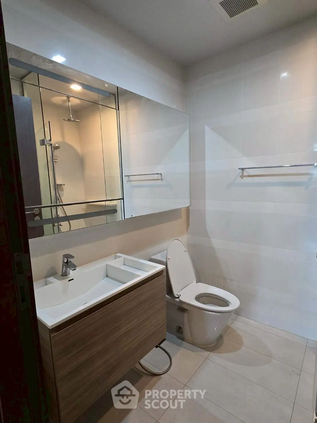 Modern bathroom with sleek vanity and large mirror in a contemporary home.