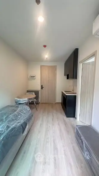 Modern studio apartment with sleek kitchen and cozy living area, perfect for urban living.
