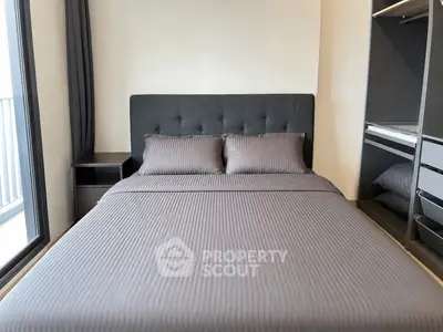 Modern bedroom with sleek design and ample natural light from large window.