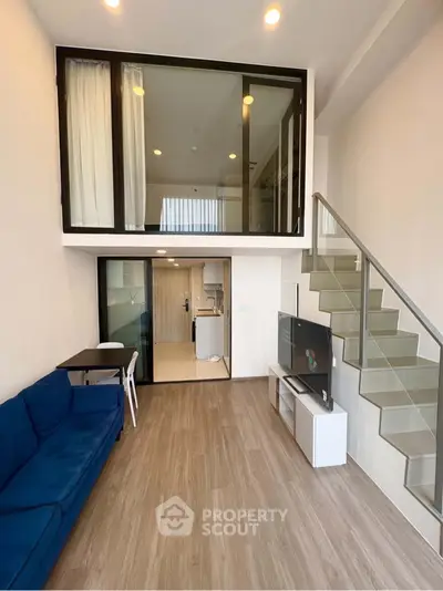 Modern loft apartment with mezzanine, stylish living area, and sleek kitchen design.
