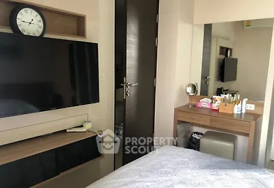 Cozy bedroom with modern TV setup and stylish vanity area