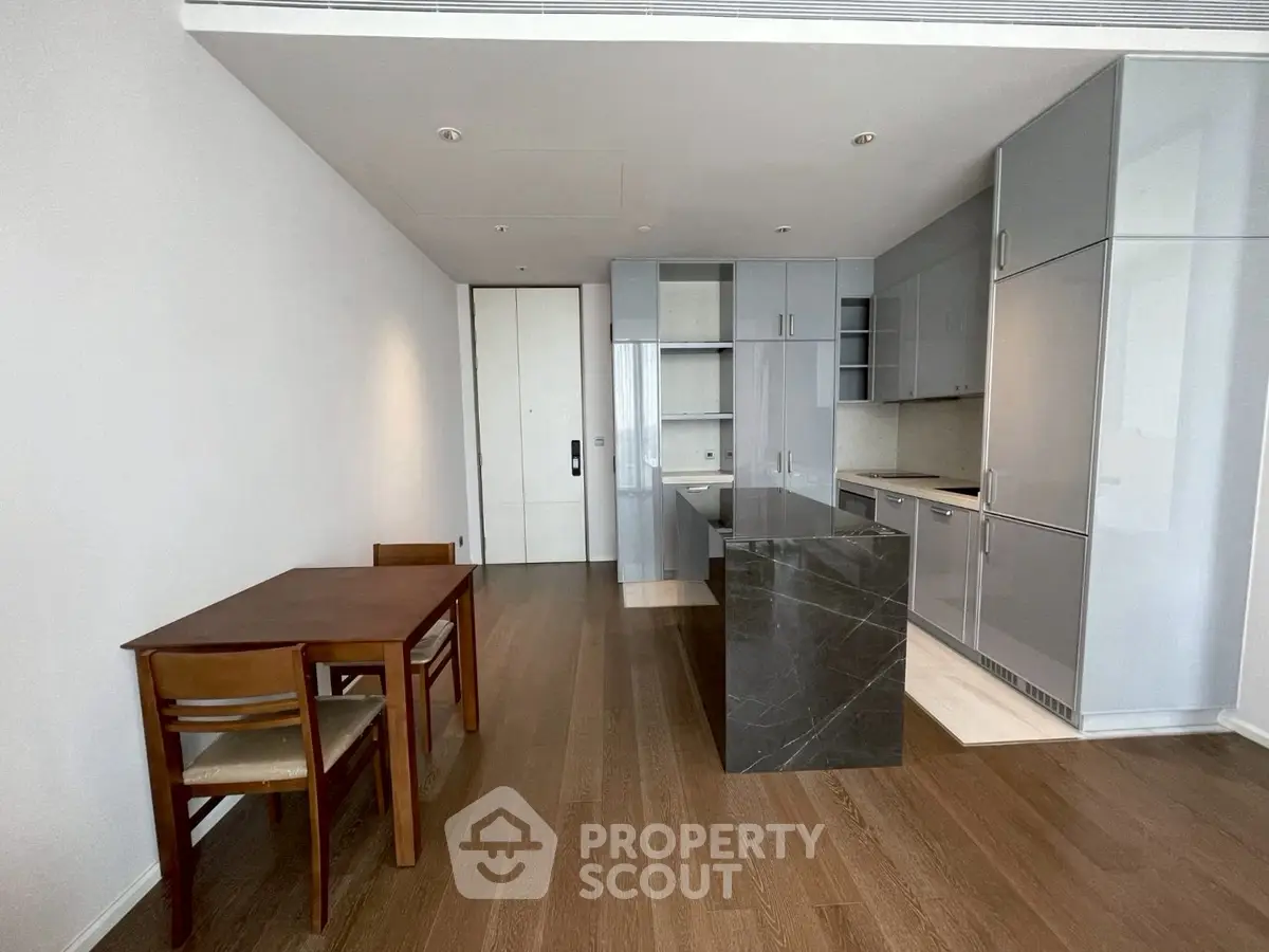 Modern kitchen with sleek cabinetry and island in open layout apartment.