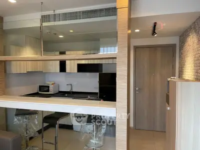 Modern kitchen with sleek design, featuring open layout and stylish bar seating.