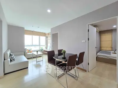 Modern apartment interior with open living and dining area, featuring sleek furniture and natural light.