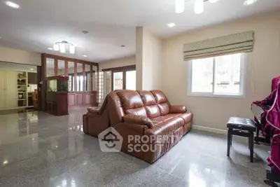 Spacious living room with leather sofa and large windows