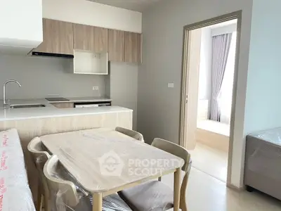 Modern kitchen with dining area in a stylish apartment, featuring sleek cabinetry and open layout.