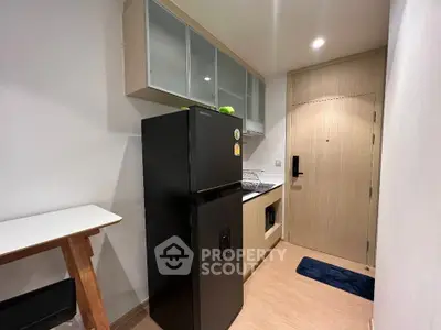 Modern kitchen with sleek black fridge and minimalist design.