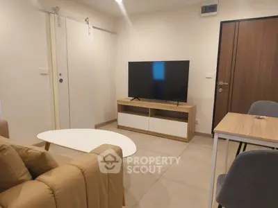 Modern living room with sleek furniture and large TV, perfect for relaxation and entertainment.