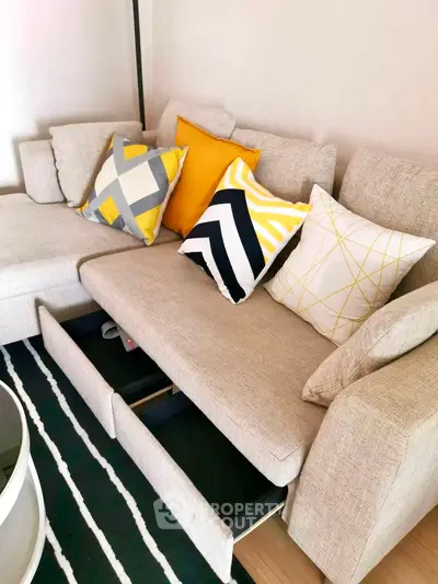 Stylish living room with modern beige sofa and colorful cushions, featuring hidden storage drawers.