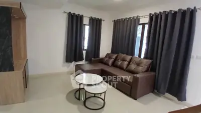 Modern living room with sleek brown sofa and stylish curtains, perfect for cozy relaxation.