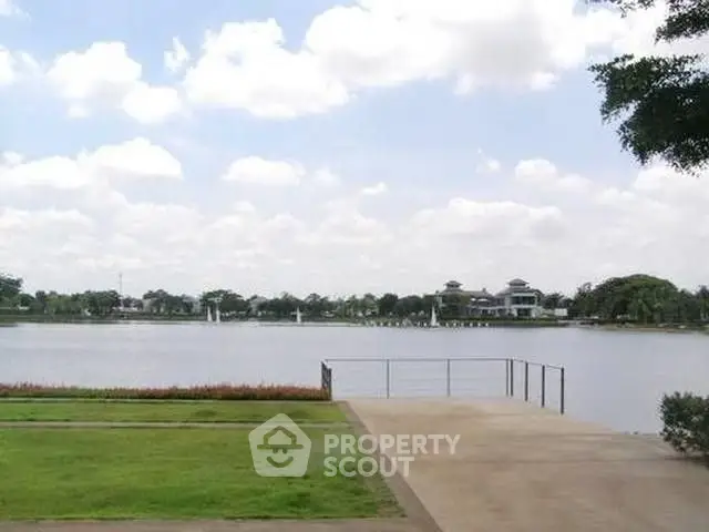 Serene lakeside view with lush greenery and clear skies