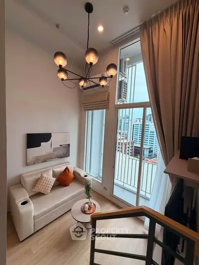 Modern living room with stylish chandelier and city view from balcony