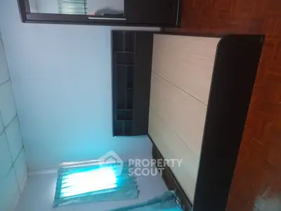 Spacious bedroom with modern bed and wooden flooring, featuring a large mirror and natural light.