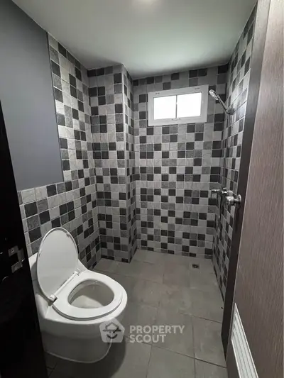 Modern bathroom with stylish tile design and compact layout.