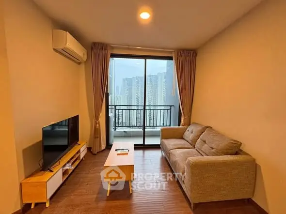 Modern living room with city view, featuring cozy sofa and sleek entertainment unit.