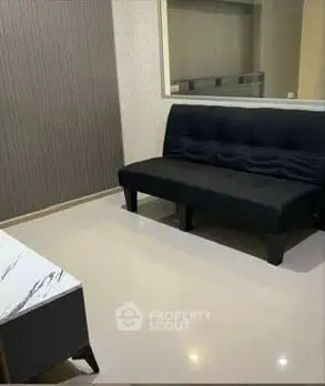 Modern living room with sleek black sofa and marble coffee table