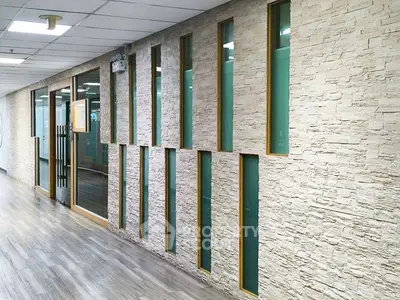 Modern office hallway with stylish stone wall and glass accents