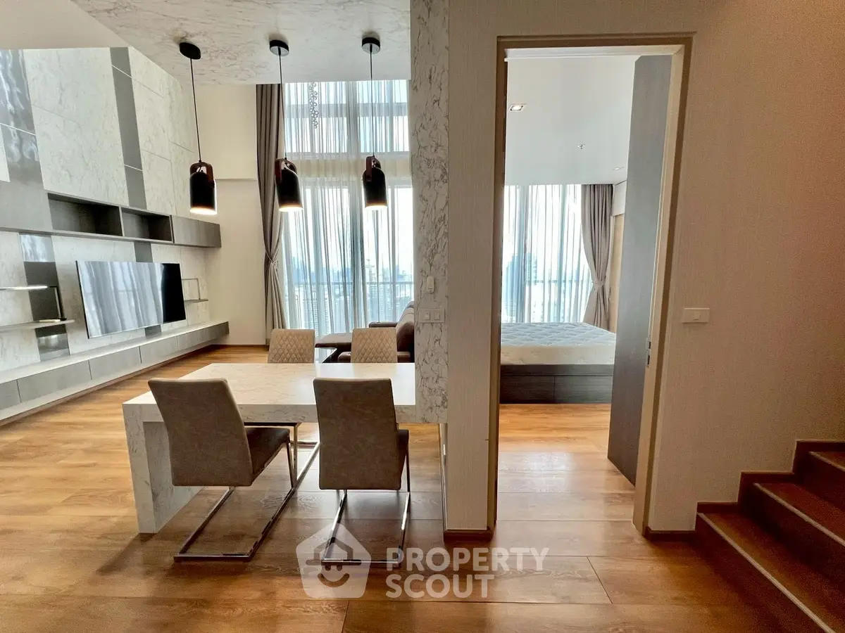 Luxurious open-plan living and dining area with modern decor and large windows offering stunning views.