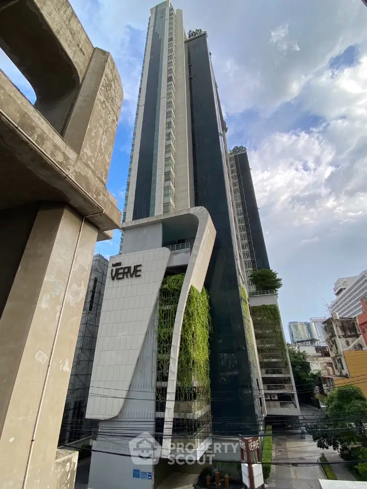 Stunning modern high-rise building with sleek architecture and lush greenery in urban setting.
