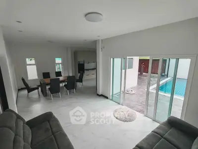 Spacious living room with pool view and modern dining area