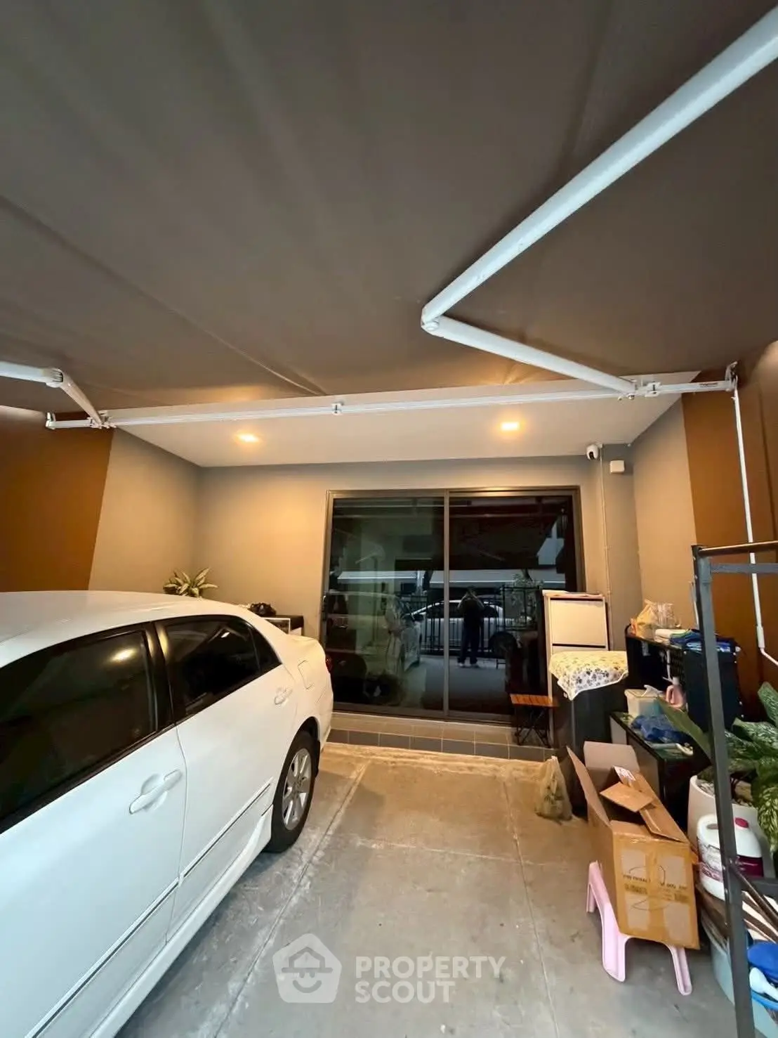 Covered parking space with car and storage area in modern home