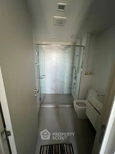 Modern bathroom with glass shower and sleek fixtures in a contemporary apartment.