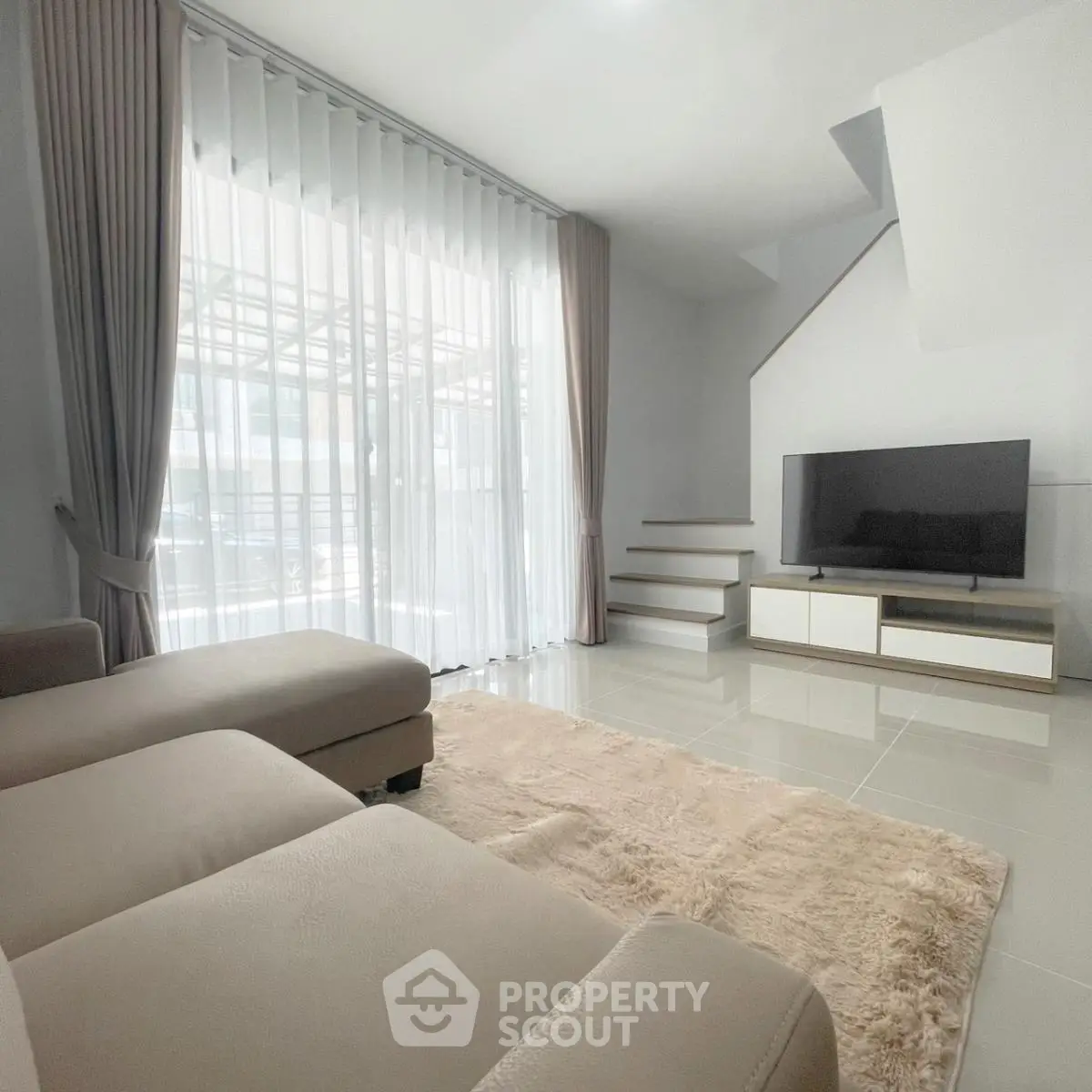 Spacious modern living room with large windows and elegant decor