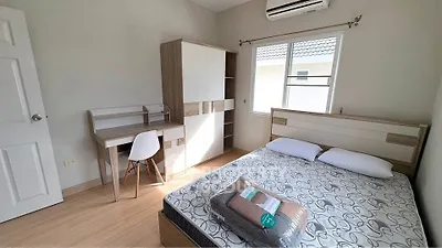 Modern bedroom with stylish furniture and natural light, featuring a cozy bed and workspace.