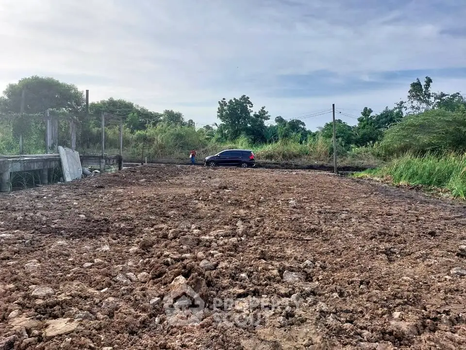 Expansive land plot ideal for development with lush greenery and clear skies.