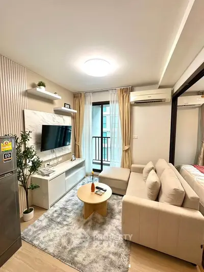 Modern living room with cozy beige sofa, wall-mounted TV, and stylish decor in a bright apartment.