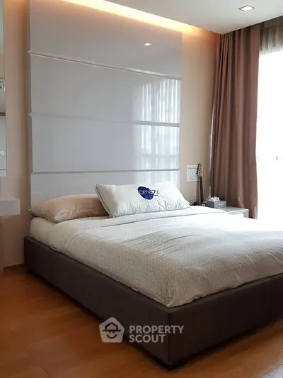 Modern bedroom with sleek design and natural light, featuring a comfortable bed and stylish decor.