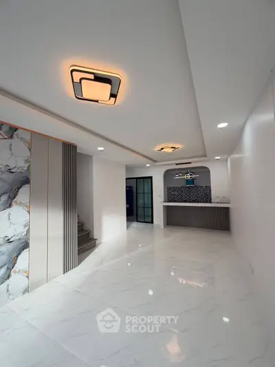 Modern interior with marble flooring and stylish lighting in open living space.