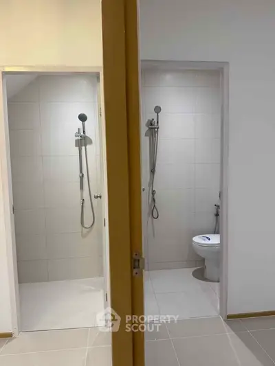 Modern dual bathroom setup with sleek shower and toilet design