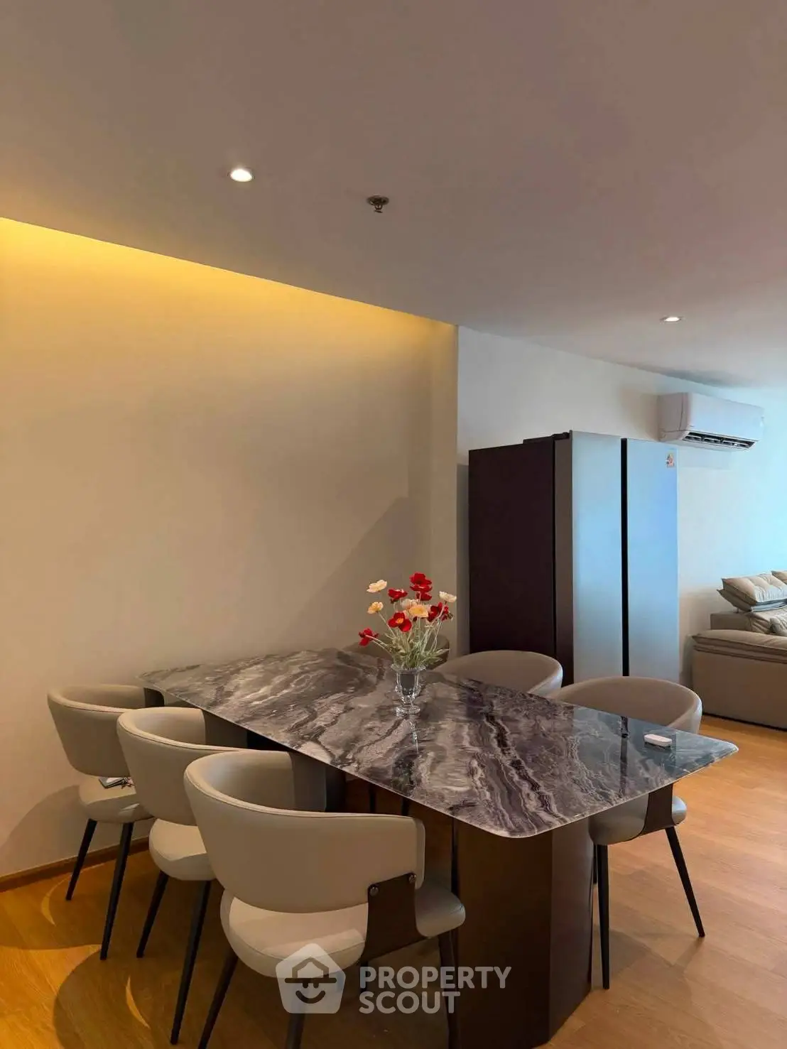 Modern dining area with elegant marble table and stylish chairs in a cozy living space.