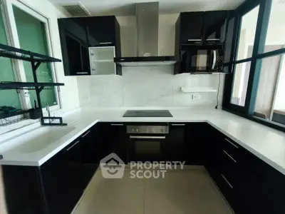 Modern kitchen with sleek black cabinetry and built-in appliances