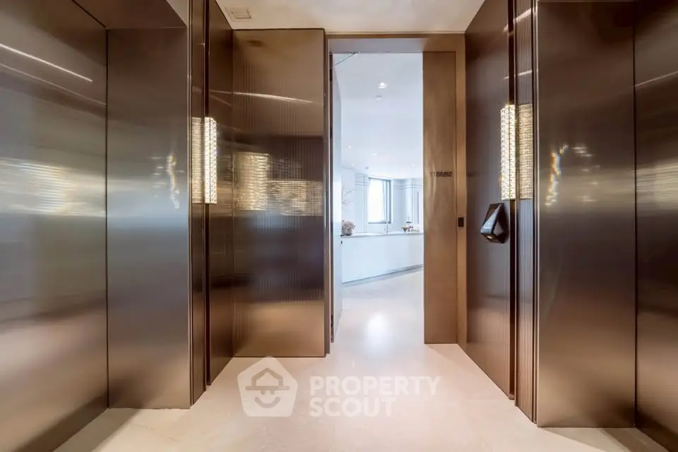 Luxurious modern elevator lobby with sleek metallic finishes and ambient lighting.