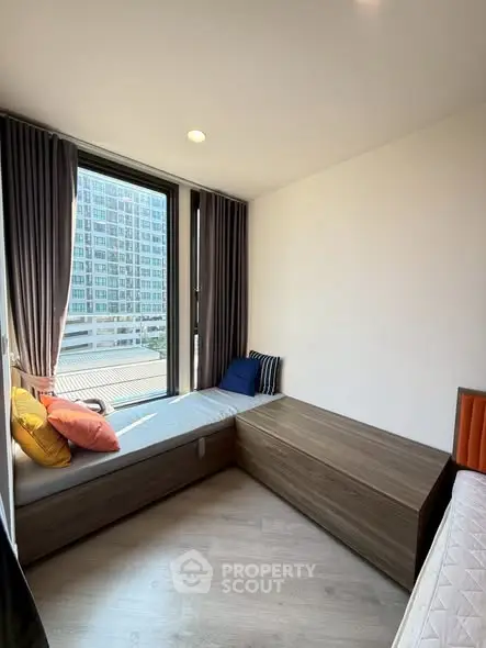 Cozy bedroom with large window and modern decor in urban apartment