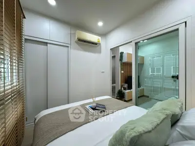 Modern bedroom with air conditioning and sliding glass door to bathroom