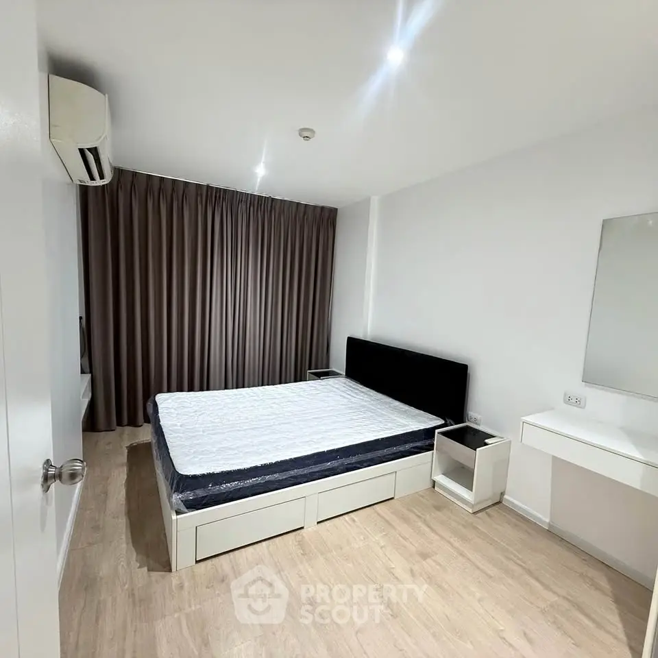 Spacious bedroom with modern furnishings and natural light, featuring a comfortable bed and sleek decor.