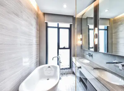 Luxurious modern bathroom with elegant bathtub and dual sinks, featuring sleek design and ample natural light.