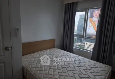 Cozy bedroom with city view, featuring a comfortable mattress and large window for natural light.