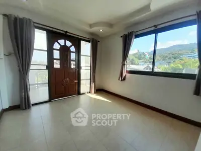 Bright room with large windows and balcony access offering scenic mountain views.