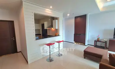 Modern open-plan living room with stylish kitchen and bar stools