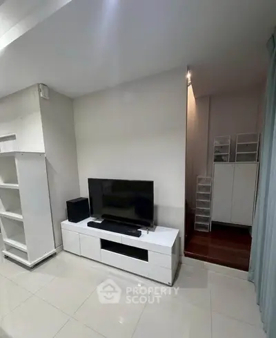 Modern living room with sleek white furniture and TV unit, perfect for contemporary living.